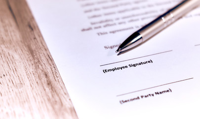 Contract sheet with a pen on a wooden background