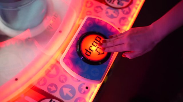 Close up of hand pushing the red lit up start button "Drop on a vintage game