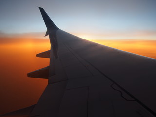Fototapeta na wymiar Airplane wing with Sunset Background from Air