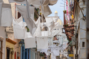 White sheets are hung on the street of old Havana against the backdrop of the Capitol building. Urban flavor