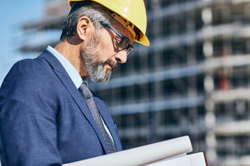 senior businessman architect helmet construction site building architecture