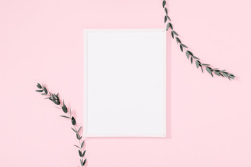 Minimal composition of eucalyptus.Photo frame, eucalyptus branches, leaves on pastel pink background. Valentines Day, Easter, Happy Women's Day, Mother's day. Flat lay, top view, copy space
