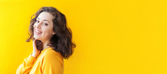 Happy girl smiling. Beauty portrait young happy positive laughing brunette woman on yellow...