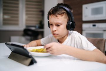 Naklejka premium Boy eating using digital devices.