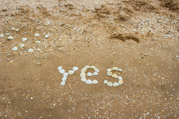 Inscription on sand from shells - yes, camping, tourism