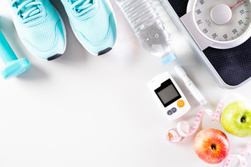 Healthy lifestyle, food and sport concept. Top view of diabetes tester set with athlete's equipment...