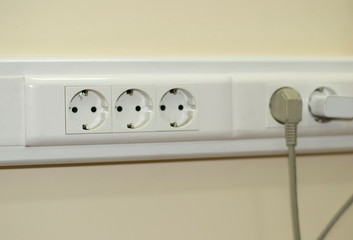 tree white Power sockets with frame on beige background wall as a background.