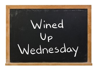 Wined up Wednesday written in white chalk on a black chalkboard isolated on white