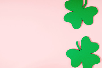 St.Patrick 's Day composition. Decoration paper green clovers or shamrocks on pastel pink...