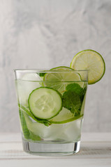 Infused water on a glass. Detox water mix of cucumber, lemon, lime and mint.
