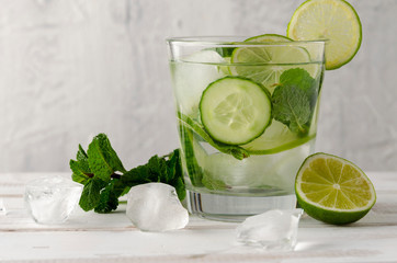 Infused water on a glass. Detox water mix of cucumber, lemon, lime and mint.