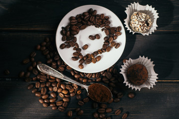Coffee on a wooden dark background. grains are scattered on the table. a spoon. composition, morning and wakefulness concept, copy space, top view