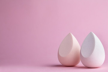 White and light pink beauty blenders.Pink background.Copy space