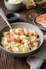 Kapustove halusky known as Strapacky, classic dish in Slovakia, boiled potato dumplings with sauerkraut and onion, topped with fried bacon and fresh chives