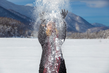 Woman is having winter fun on a  snowy, sunny day in Lika, Croatia