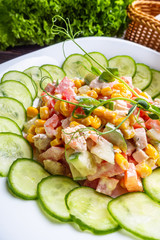 Fresh salad of vegetables and meat on wooden rustic background