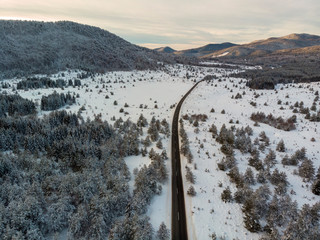 Aerial view of the road during winter with snow on dusk. Lika, Croatia