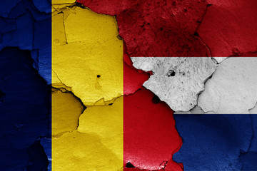 flags of Romania and Netherlands painted on cracked wall