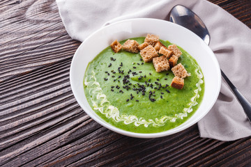 broccoli spinach cream soup on rustic wooden background