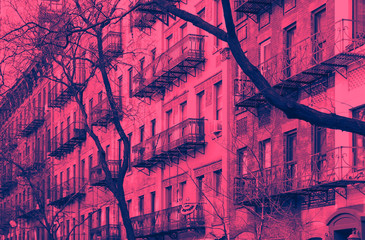 Block of colorful old buildings in the Upper East Side neighborhood of New York City in pink and...