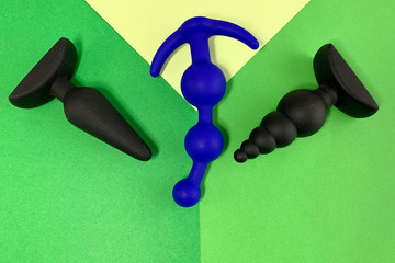 Sex toys. Three butt plags on a green background. Useful for adult, sex shop