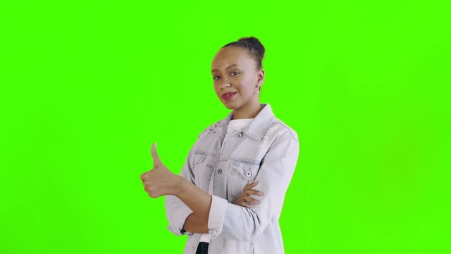 Young happy African woman giving thumbs up on green background Jean jacket