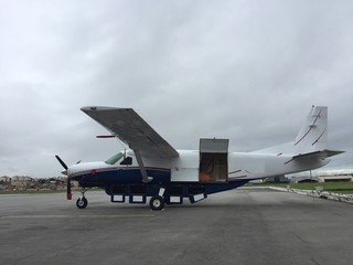 Fototapeta na wymiar Turboprop cargo plane parked in airport yard being loaded on cloudy day
