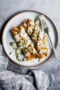 Cheesy pumpkin taquitos with roasted jalapeno pepita crema