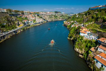 Fototapeta na wymiar Boats sailing on the Douro River in a beautiful early spring day