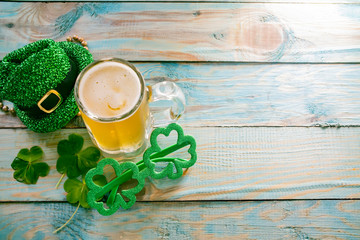 St. Patricks Day green shamrocks with a full cold frosty glass of beer   background