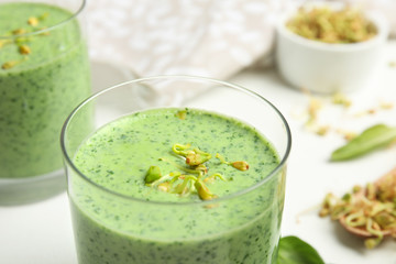Green buckwheat smoothie on white table, closeup