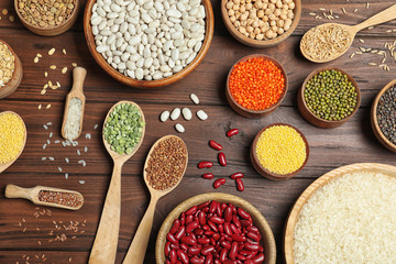 Flat lay composition with different types of legumes and cereals on wooden table. Organic grains