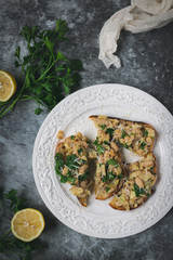 Toast slices with white lemon beans on top, styled dark background