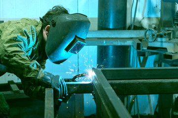 The welder performs welding work with semi-automatic arc welding. Welding stainless steel pipes. Welding MIG.