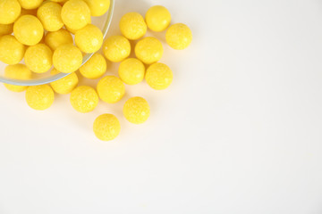 Tasty lemon drops on white background, top view