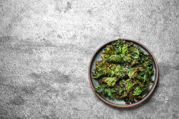 Obraz na płótnie Canvas Tasty baked kale chips on grey table, top view. Space for text