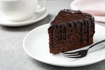 Delicious chocolate cake on light grey table, closeup