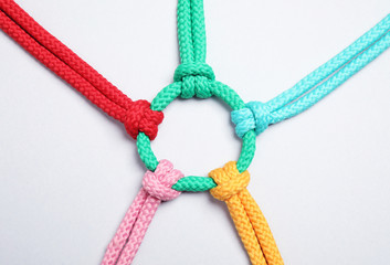 Colorful ropes tied together on white background, top view. Unity concept
