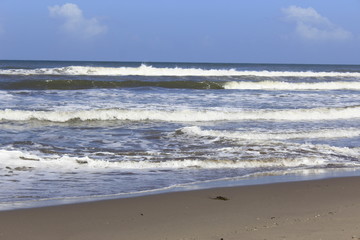 Fototapeta na wymiar waves on the shore of the Beach, blue sky