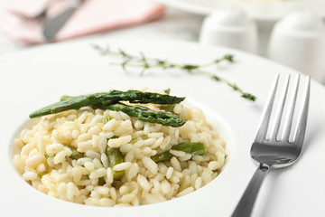 Delicious risotto with asparagus in plate, closeup