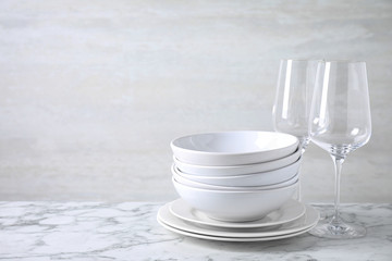 Set of clean dishware on marble table. Space for text