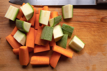 zanahorias y calabacines cortados sobre tabla y cuchillo a lado