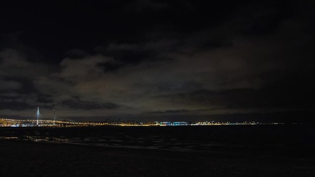 View from the Gulf of Finland on the Saint Petersburg's bridges and buildings illuminated by lights against the cloudy night sky. Concept. Saint Petersburg's night scenery