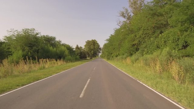 Driving Riding  a Car bike on a Country side Road, valley � POV Plate - Point of view front � Flying camera sunset. Drone