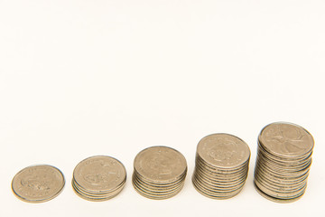 Canadian Quarters stacked into five ascending piles on white background.