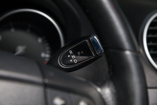 Automatic gear knob under steering wheel in black for driving and acceleration. Abstract image of fast speed.