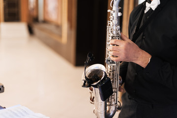 Fototapeta premium hands of a male musician saxophonist playing music on a saxophone close up
