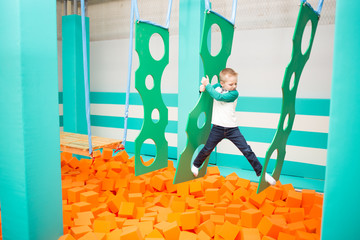 Happy boy plays over foam pit