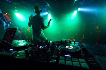 Naklejka na ściany i meble artist with a microphone performs on the stage of a nightclub