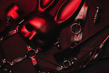 Set of erotic toys from a sex shop. Mask, leather belt, choker, handcuffs, whip and anal plug